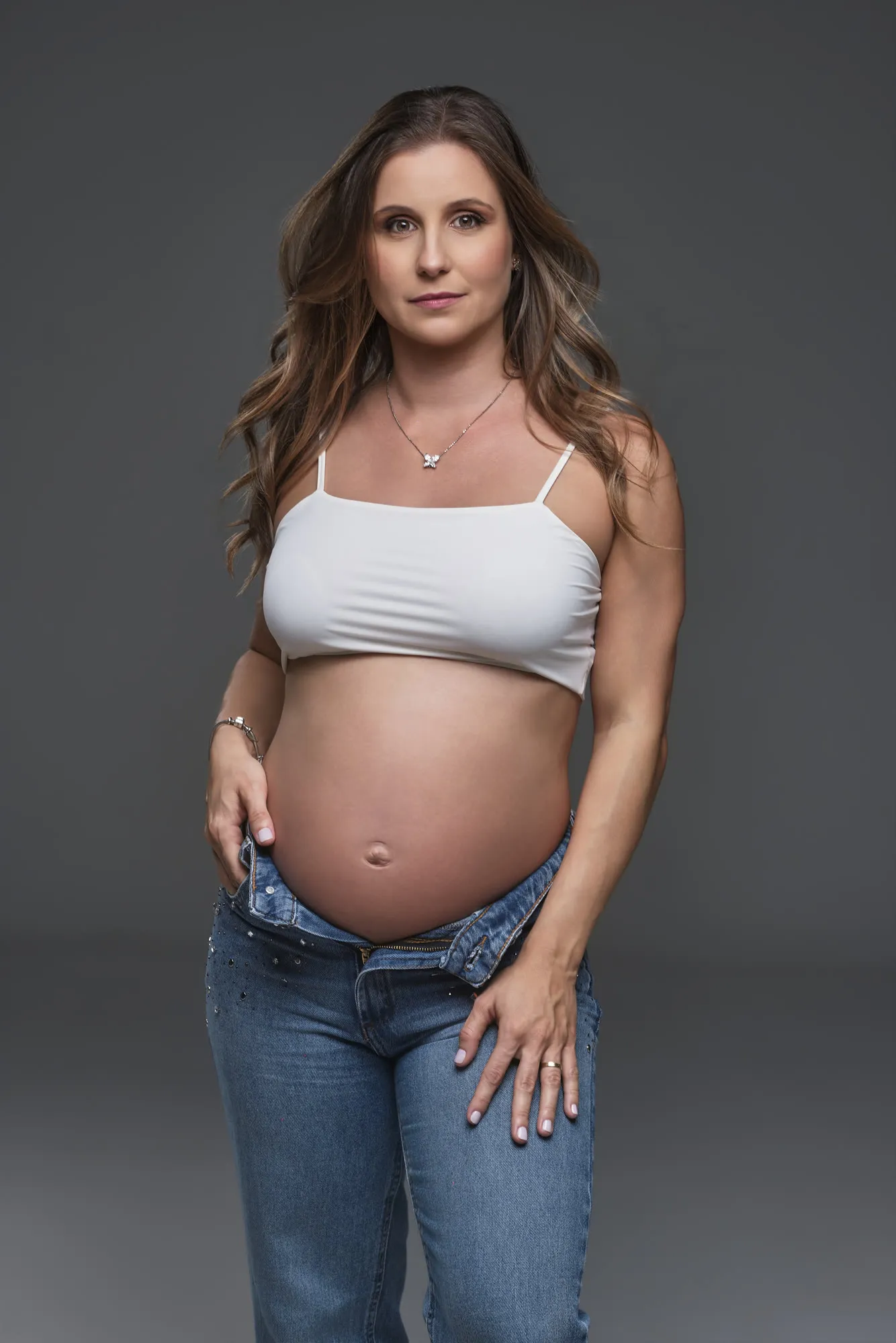 Gestante de jeans em retrato de estúdio
